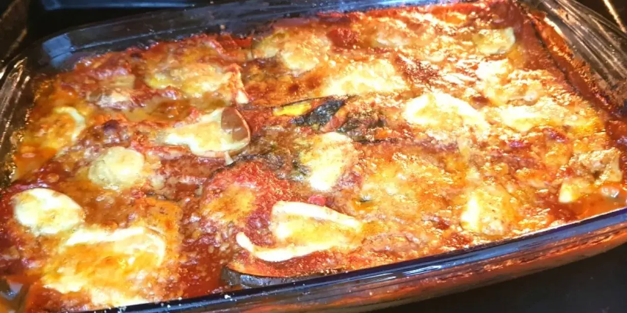 Un invitante pasticcio di melanzane appena sfornato, con strati dorati di formaggio fuso e salsa rossa.