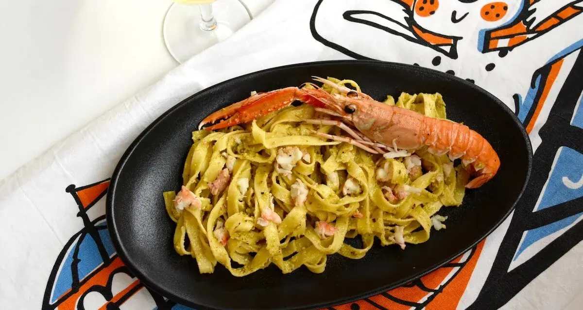 Tagliatelle con scampi e un cremoso pesto di pistacchio, un piatto che sa di mare e Sicilia.