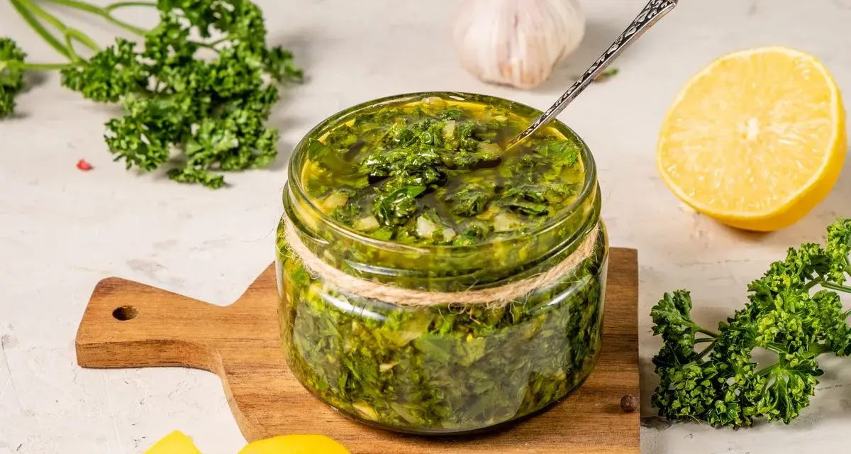 Un vasetto di salmoriglio ricetta, con prezzemolo fresco, limone e aglio, pronto per insaporire i tuoi piatti.