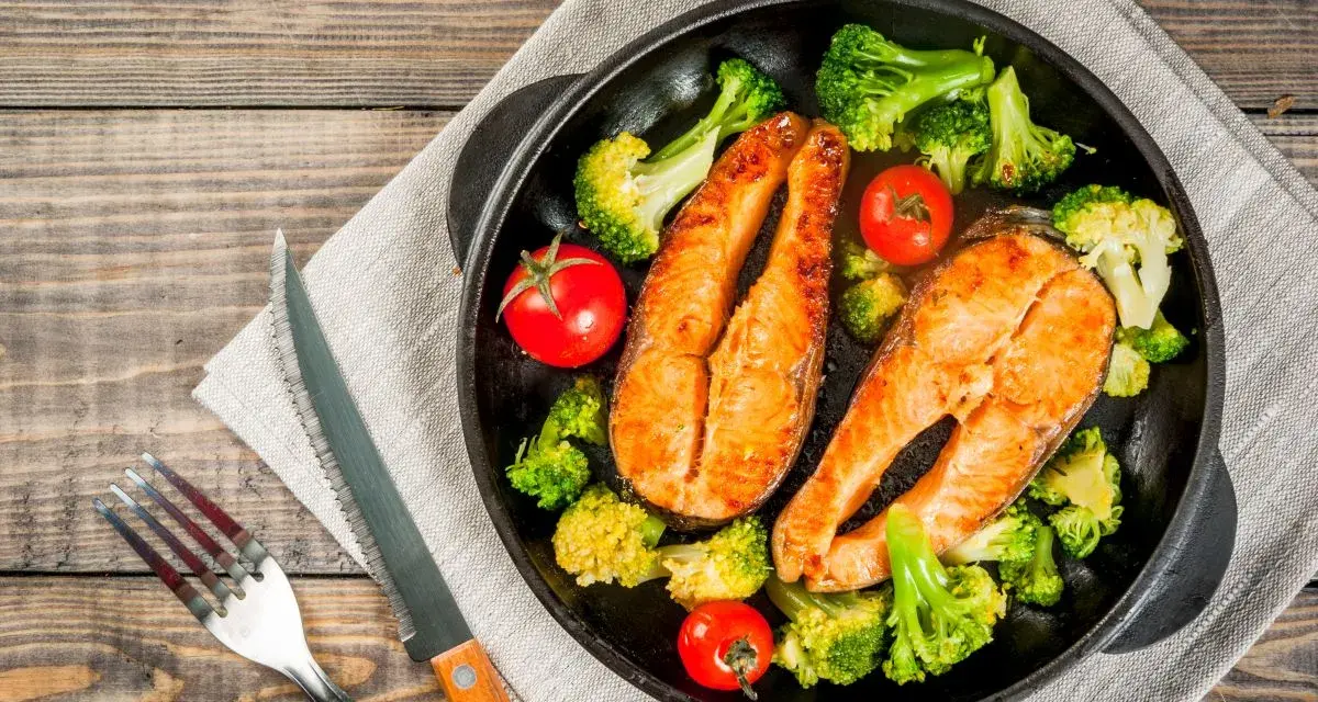 Due tranci di salmone succulento, cotti in padella, accompagnati da broccoli croccanti e pomodorini freschi. Un piatto sano e gustoso.