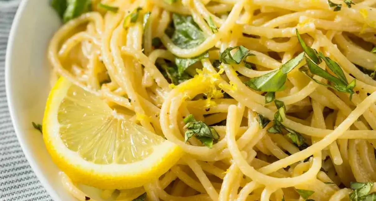Spaghetti al limone, un classico della ricetta della Costiera Amalfitana, guarniti con scorza di limone e basilico fresco.