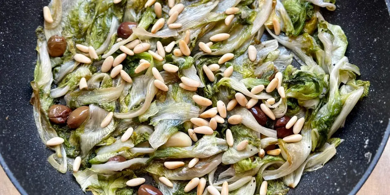 Scarola in padella con olive e pinoli, un contorno saporito e leggero.