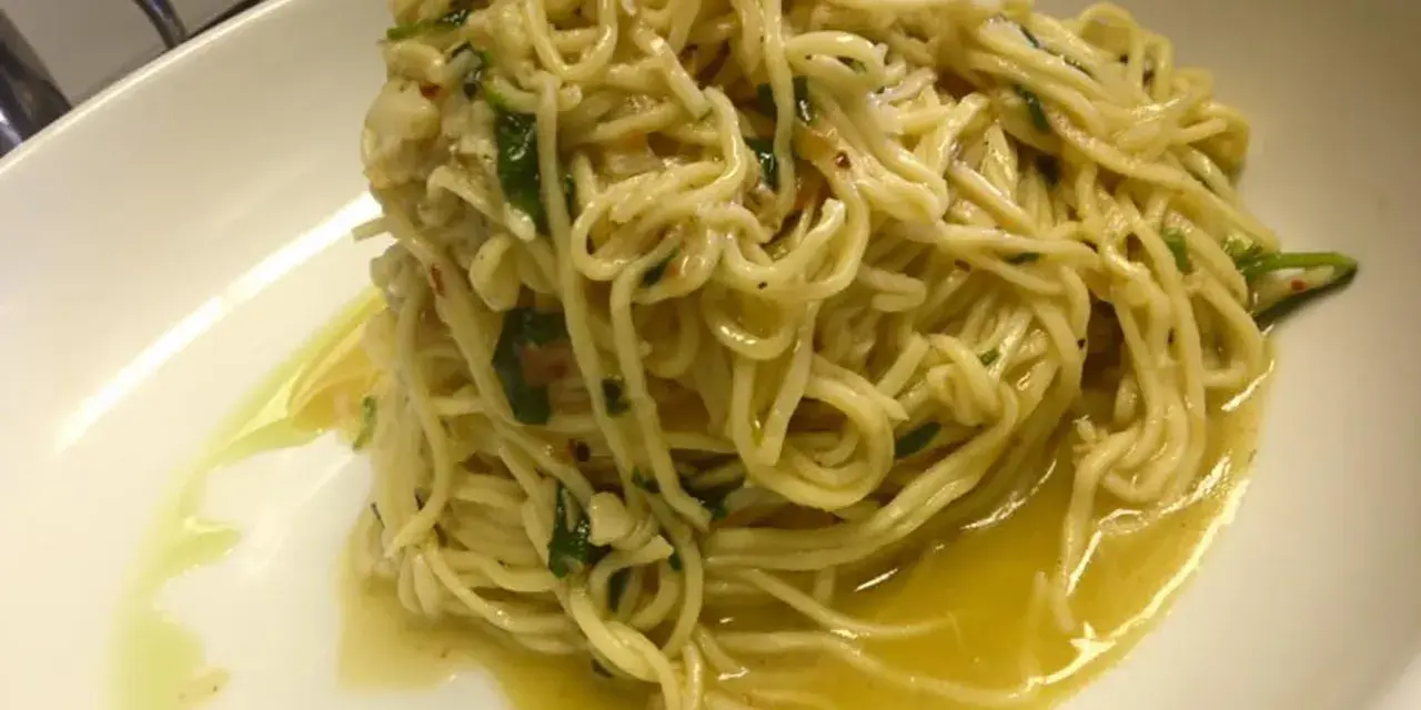 Spaghetti aglio olio e peperoncino cremosi, un piatto semplice ma ricco di sapore, con un filo d'olio che invita al primo assaggio.