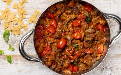 Sugo con melanzane e pomodorini in padella, pronto per condire la pasta.