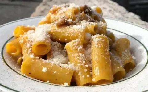 Rigatoni cremosi, un assaggio della vera carbonara ricetta originale romana Sora Lella, con guanciale croccante e pecorino romano.