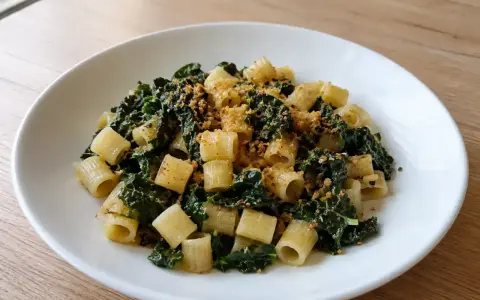 Piatto di pasta con cavolo nero e acciughe, condita con pangrattato croccante.