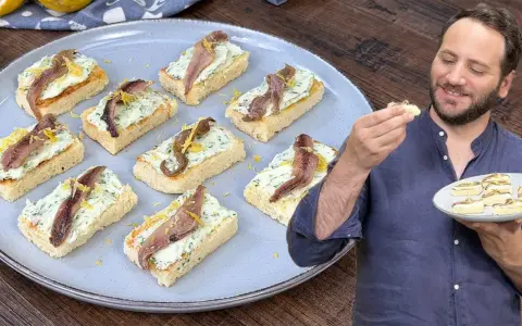 Deliziosi crostini con acciughe e robiola, guarniti con scorza di limone, pronti per essere gustati.