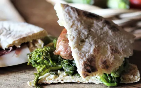 Torta al testo ripiena di salsiccia e verdure, un sapore autentico.