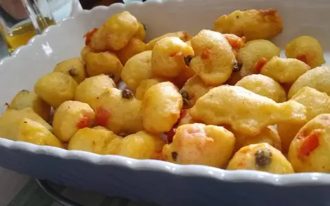 Pittule salentine dorate e fragranti, un tripudio di sapori pugliesi in un piatto.
