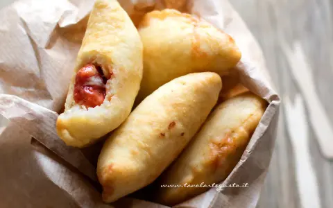 Panzerotti pugliesi dorati e fragranti, uno aperto rivela un ripieno succulento.