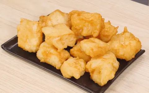 Un piatto di invitante baccalà fritto, dorato e croccante, pronto per essere gustato.
