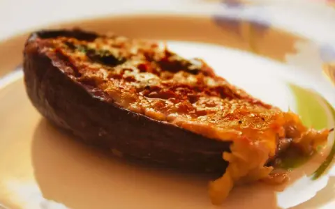 Melanzane ripiene calabresi, un piatto saporito con un ripieno dorato e filante, pronto per essere gustato.
