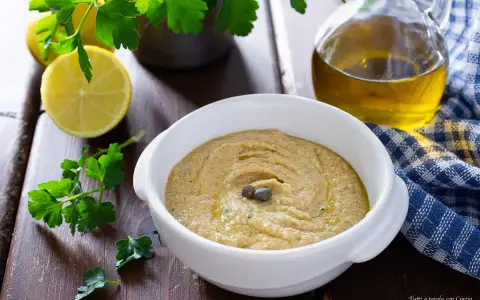 Una cremosa salsa tonnata con uova sode, guarnita con capperi, pronta per essere gustata.