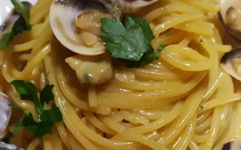Spaghetti alle vongole cremosi come al ristorante, un piatto invitante con vongole fresche e prezzemolo.