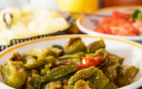 Un piatto di peperonata ricetta della nonna, con peperoni verdi e qualche pomodoro, cotta lentamente per un sapore autentico.