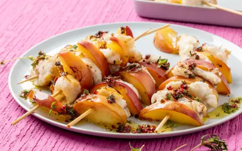 Spiedini per aperitivo veloci con pesche succose e bocconcini di pesce bianco, conditi con erbe aromatiche e olio.