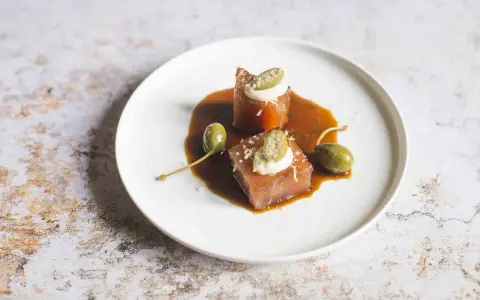Cubetti di tonno vitellato con salsa bruna, capperi e una quenelle di maionese.
