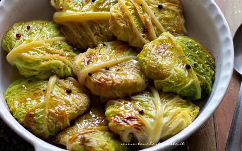 Verza ripiena in teglia, condita con olio e pepe nero. Un piatto confortante e saporito, pronto per essere gustato.