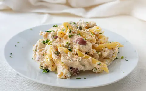Piatto di pasta cremosa con tonno, olive nere e capperi, guarnita con prezzemolo fresco. Un classico della pasta tonno e olive.