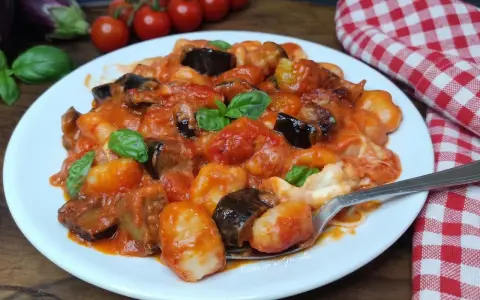 Gnocchi all'ortolana con melanzane, pomodorini e basilico fresco, un piatto colorato e saporito.