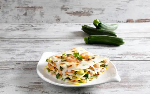 Lasagna estiva con zucchine e gamberetti, un piatto leggero e saporito, perfetto per le giornate calde.