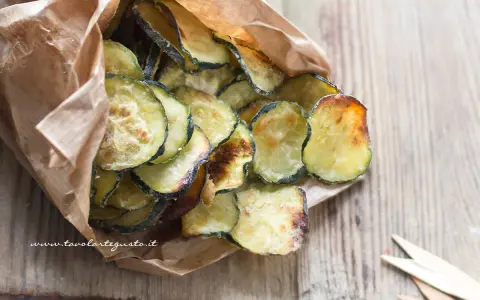 Delizioso contorno di zucchine fritte, croccanti e dorate, servite in un sacchetto di carta.