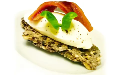 Crostini con burrata cremosa, alici del Cantabrico e basilico fresco. Un boccone di puro piacere.