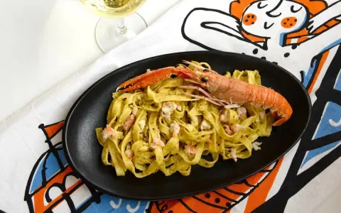 Tagliatelle con scampi e un cremoso pesto di pistacchio, un piatto che sa di mare e Sicilia.