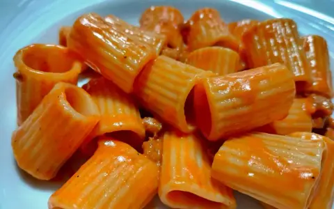 Un primo piatto invitante: rigatoni conditi con un sugo rosso cremoso, un'autentica pasta alla carcerata.