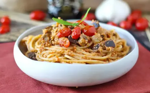 Spaghetti al tonno ricetta della nonna: un piatto gustoso con melanzane, pomodorini e basilico.