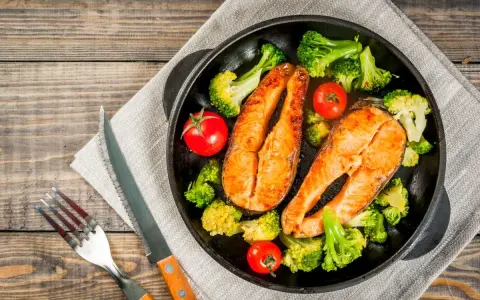 Due tranci di salmone succulento, cotti in padella, accompagnati da broccoli croccanti e pomodorini freschi. Un piatto sano e gustoso.