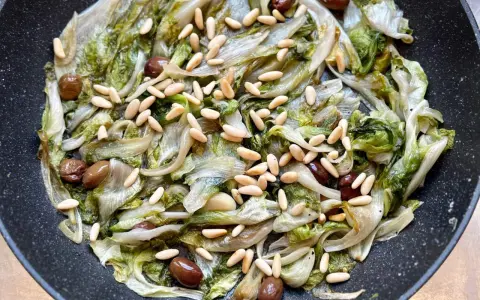 Scarola in padella con olive e pinoli, un contorno saporito e leggero.
