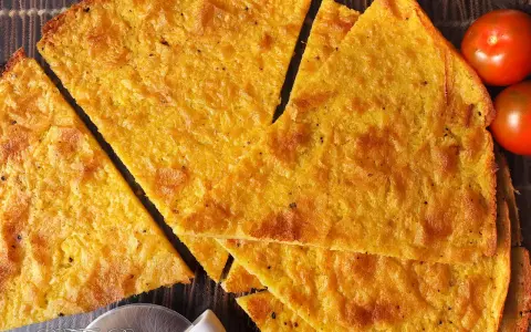 Fetta di cecina dorata, croccante e profumata, pronta per essere gustata. Una deliziosa cecina ricetta da provare subito!