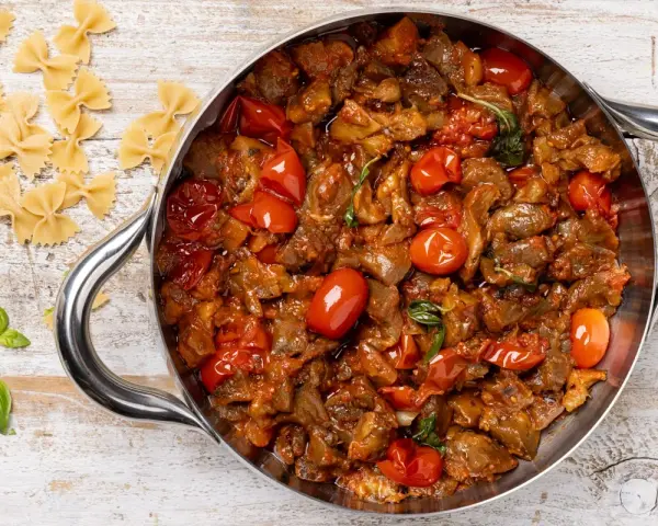 Sugo con melanzane e pomodorini in padella, pronto per condire la pasta.