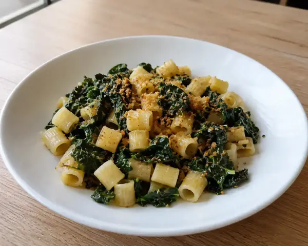 Piatto di pasta con cavolo nero e acciughe, condita con pangrattato croccante.