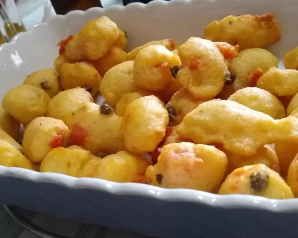 Pittule salentine dorate e fragranti, un tripudio di sapori pugliesi in un piatto.