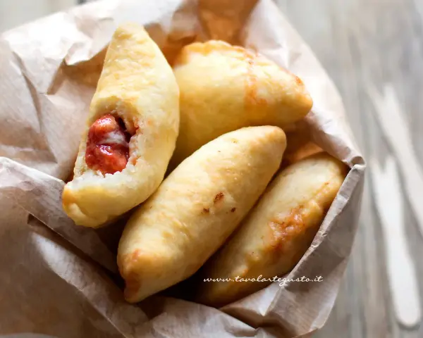 Panzerotti pugliesi dorati e fragranti, uno aperto rivela un ripieno succulento.