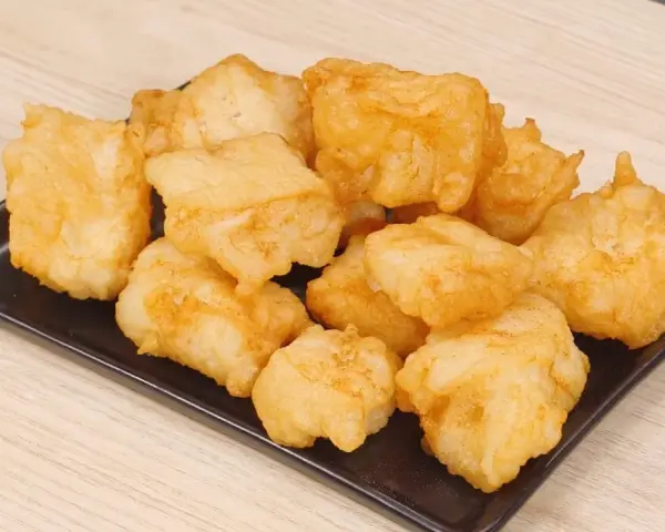 Un piatto di invitante baccalà fritto, dorato e croccante, pronto per essere gustato.