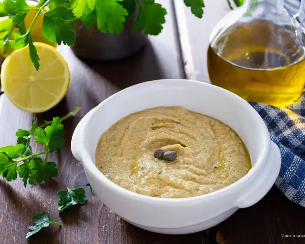 Una cremosa salsa tonnata con uova sode, guarnita con capperi, pronta per essere gustata.