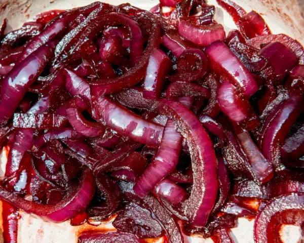 Cipolla rossa caramellata, lucida e succosa, pronta per arricchire ogni piatto con il suo sapore dolce e intenso.