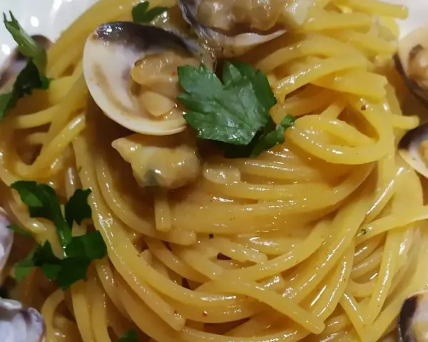Spaghetti alle vongole cremosi come al ristorante, un piatto invitante con vongole fresche e prezzemolo.