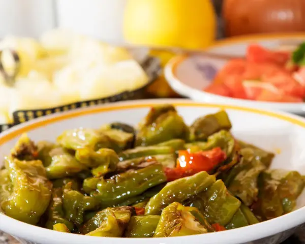 Un piatto di peperonata ricetta della nonna, con peperoni verdi e qualche pomodoro, cotta lentamente per un sapore autentico.