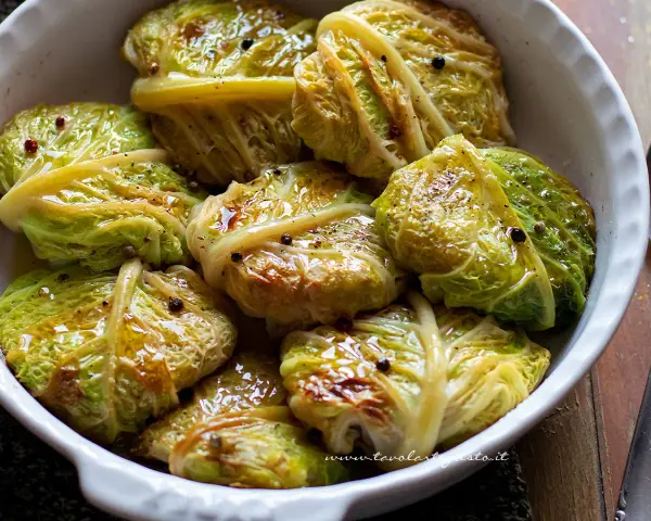 Verza ripiena in teglia, condita con olio e pepe nero. Un piatto confortante e saporito, pronto per essere gustato.