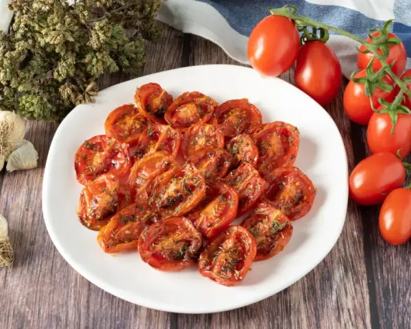 Pomodorini confit in friggitrice ad aria, conditi con erbe aromatiche e aglio. Un contorno saporito e facile da preparare.