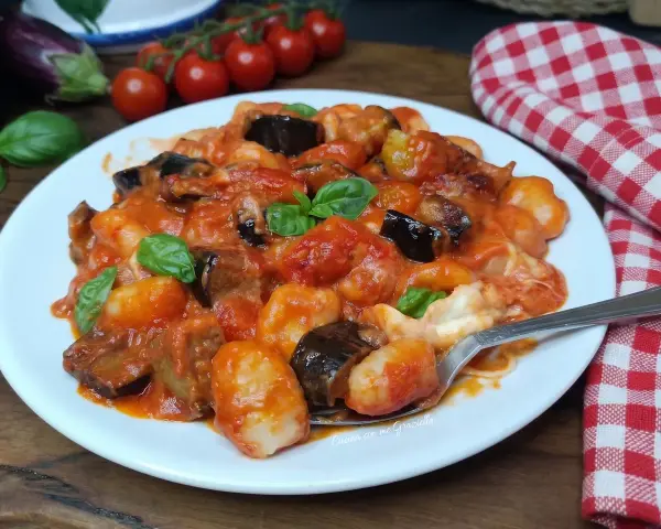 Gnocchi all'ortolana con melanzane, pomodorini e basilico fresco, un piatto colorato e saporito.