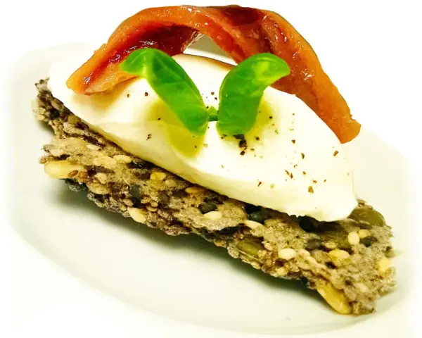 Crostini con burrata cremosa, alici del Cantabrico e basilico fresco. Un boccone di puro piacere.