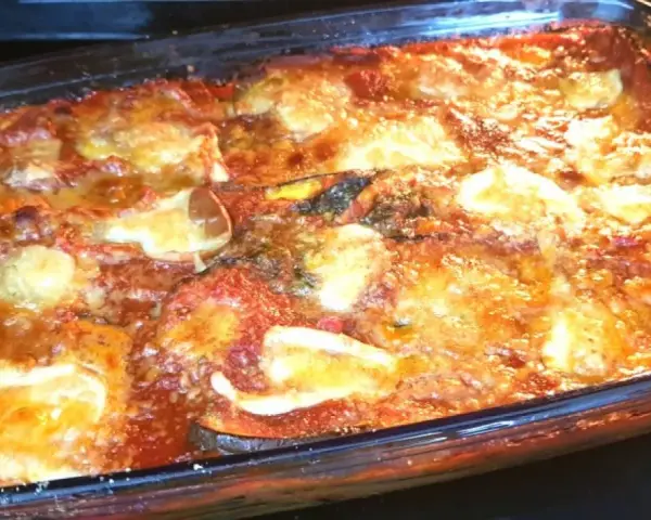 Un invitante pasticcio di melanzane appena sfornato, con strati dorati di formaggio fuso e salsa rossa.
