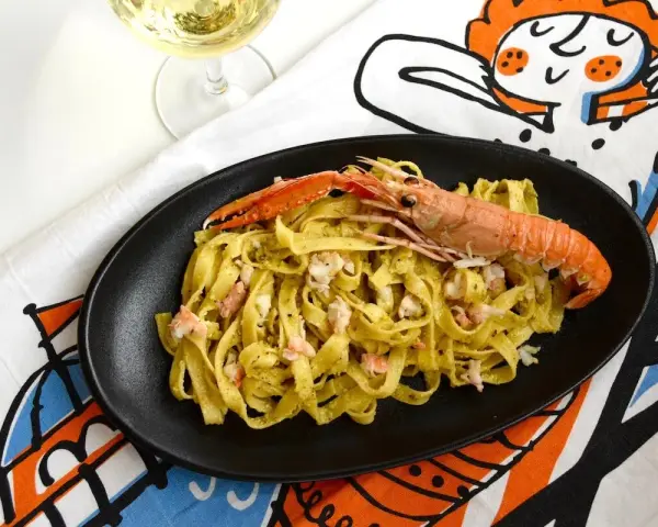 Tagliatelle con scampi e un cremoso pesto di pistacchio, un piatto che sa di mare e Sicilia.