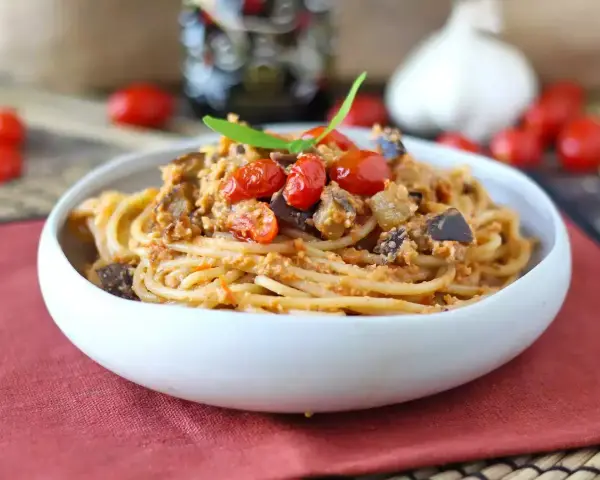 Spaghetti al tonno ricetta della nonna: un piatto gustoso con melanzane, pomodorini e basilico.