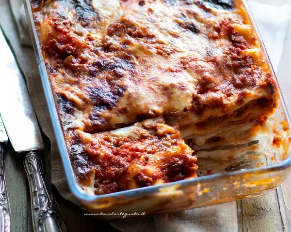 Lasagna alla bolognese appena sfornata, con strati dorati e ripieno succulento, pronta per essere gustata.